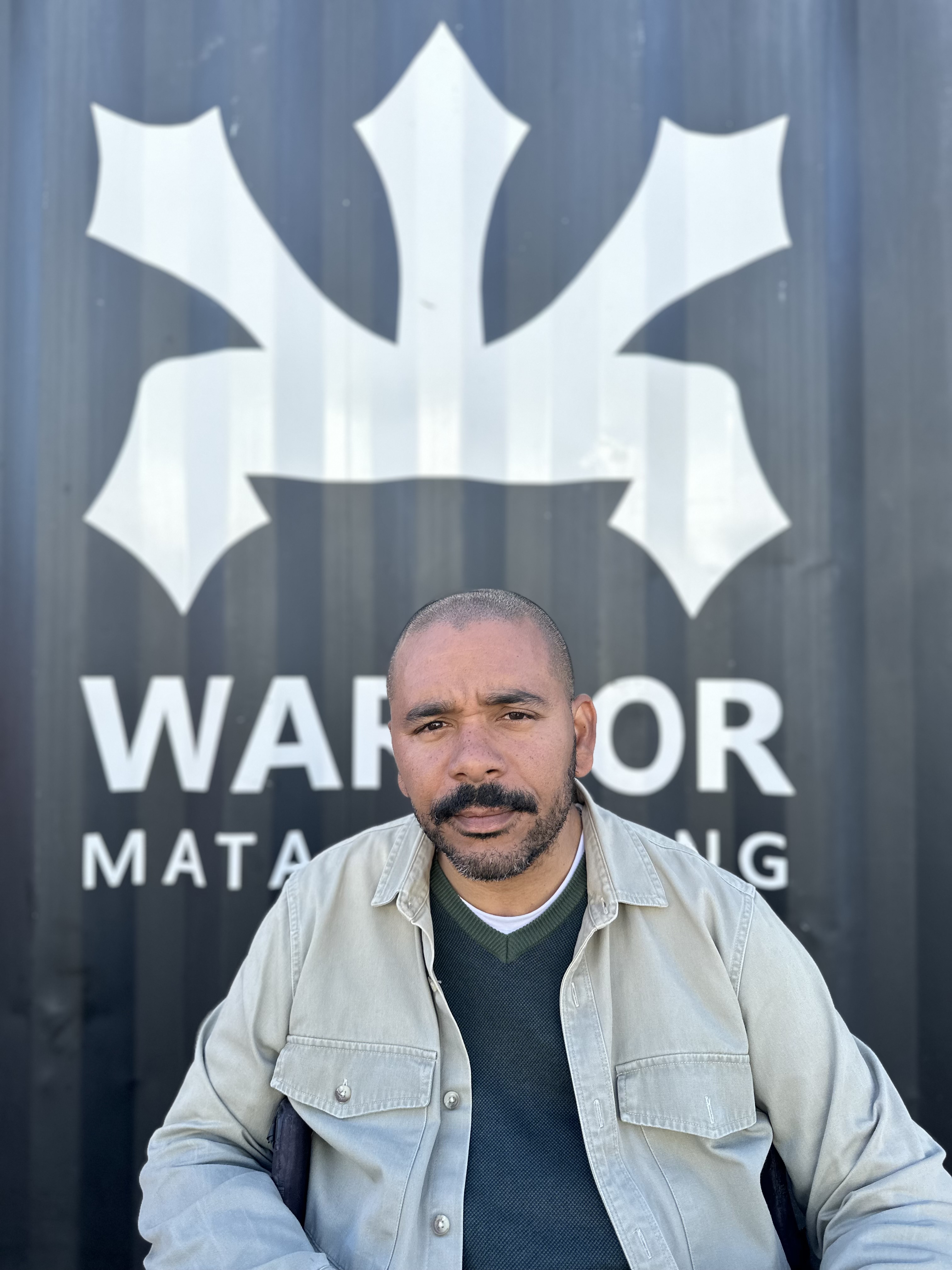 Nuno de Carvalho Mata junto à identidade da Warrior Mata Clothing